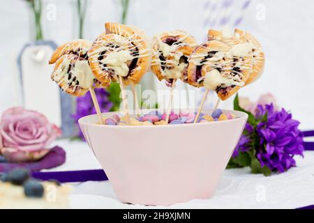 Mini blueberry pastries on sticks in a pink bowl Stock Photo