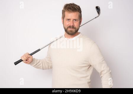 Young handsome man playing golf standing isolated over white background. Stock Photo