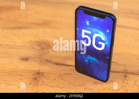 Smartphone with 5G network connection. Wooden background photo Stock Photo