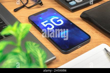 Phone with 5G network, hologram background. Business desktop. Concept of high speed internet, new generation of networks Stock Photo