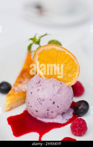 Blueberry ice cream with candied oranges on a lemon tart Stock Photo