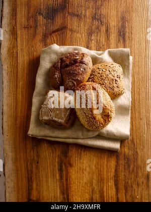 Fresh bread rolls on a folded kitchen towel Stock Photo