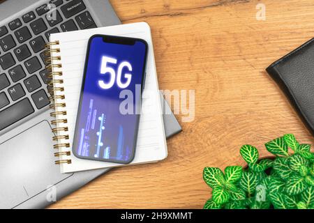 Modern mobile phone with 5G network, hologram background. Business desktop. Concept of high speed internet, new generation of networks Stock Photo