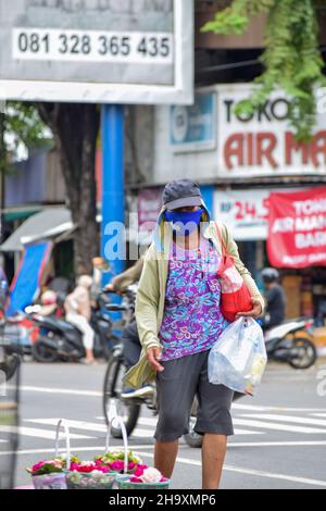 A hardworker scavenger pulling his cart in a cloudy morning after rain, on asphalt road. Solo - Indonesia. December 9, 2021 Stock Photo