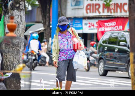 A hardworker scavenger pulling his cart in a cloudy morning after rain, on asphalt road. Solo - Indonesia. December 9, 2021 Stock Photo