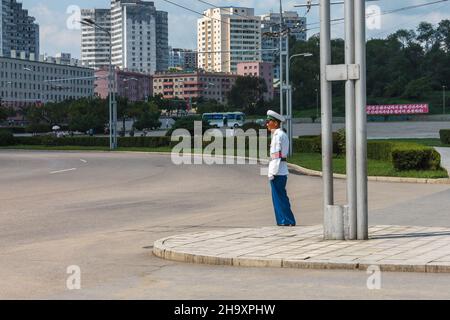 Pyongyang, North Korea - July 27, 2014: A police officer regulates traffic at an intersection in Pyongyang. Traffic police in Pyongyang. Stock Photo