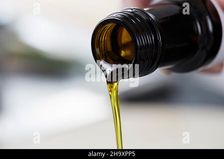 Flaxseed oil being poured from a bottle Stock Photo