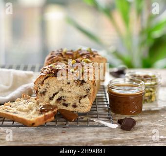 Vegan bread with a quark and chocolate filling sprinkled with pistachio nuts with caramel sauce Stock Photo