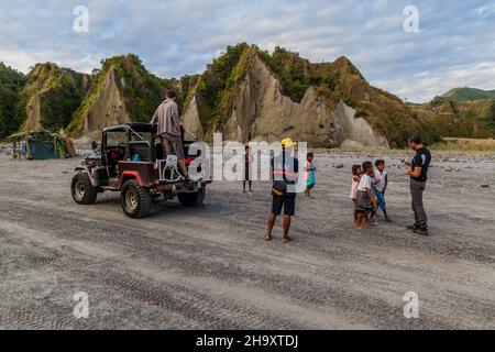 MT PINATUBO, PHILIPPINES - JAN 30, 2018: Tourists with local children on a lahar of Pinatubo volcano. Stock Photo