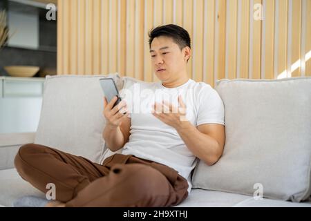 Asian man having video call on smartphone Stock Photo