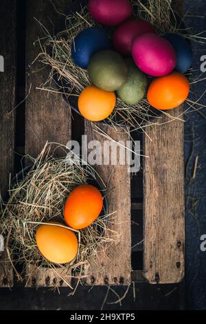 Easter eggs coloured with organic dyes in a nest Stock Photo