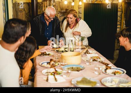 Happy latin family cooking together during dinner time at home - Soft focus on grandmother face Stock Photo