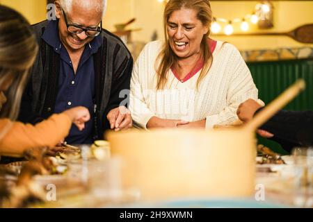 Happy latin family cooking together during dinner time at home - Focus on grandmother face Stock Photo