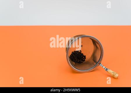 metal tea strainer on an orange paper background Stock Photo