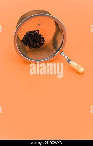 metal tea strainer on an orange paper background Stock Photo