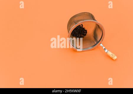 metal tea strainer on an orange paper background Stock Photo