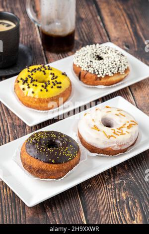 Delicious donuts decorated with different decorations on wooden table Stock Photo