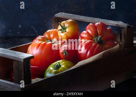 Various types of tomatoes in crate Stock Photo