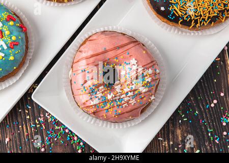Delicious donuts decorated with different decorations on wooden table Stock Photo