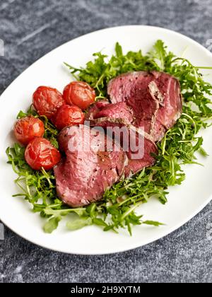 Tagliata di Manzo (beef fillet on a bed of rocket with cocktail tomatoes, Italy) Stock Photo