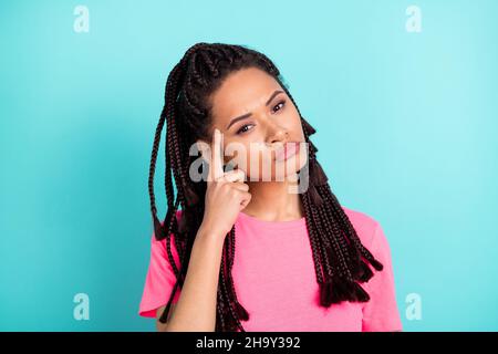 Photo of serious minded thoughtful girl finger temple think wear pink t-shirt isolated on blue color background Stock Photo