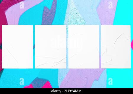 colorful urban wall with four wrinkled glued poster templates Stock Photo