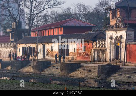 People across the very polluted Bagmati River in the Pashupatinath Temple complex in Kathmandu, Nepal in early morning. Stock Photo