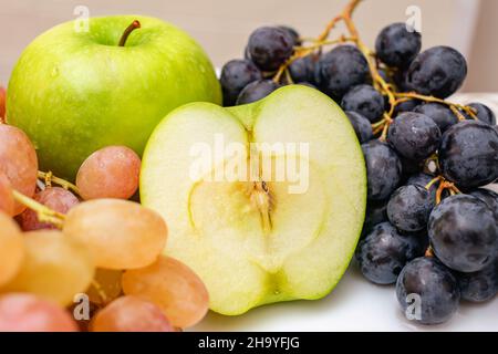 Delicious green apples and different varieties of grapes on the festive table Stock Photo