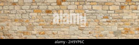 Light brown stone wall in panoramic close-up made of natural stones Stock Photo
