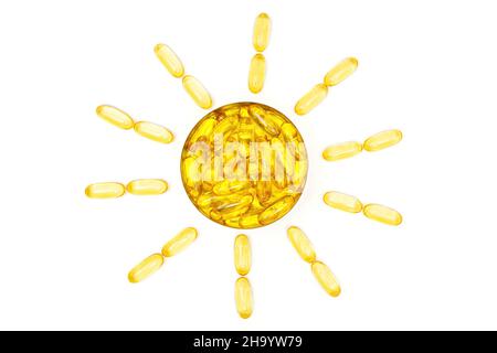 Translucent fish oil omega-3 softgel capsules arranged into a sun shape isolated on white background. Dietary supplement boosting skin immunity to sun Stock Photo