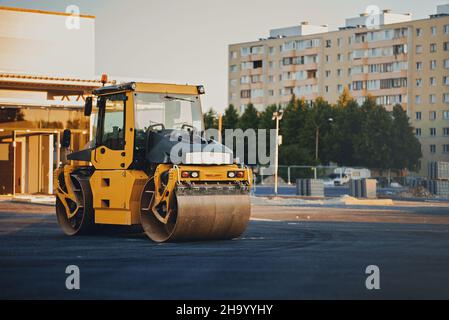 Road reconstruction. Heavy vibration road roller stacking hot asphalt. Stock Photo