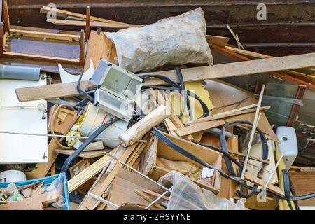 Many old home appliances and furniture in garbage container. Stock Photo