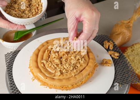 Confectioner putting walnuts in the brigadeiro filling (top view). Stock Photo