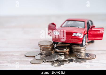 Car on stack of coins. Car loan, Finance, saving money, insurance and leasing time concepts. Stock Photo