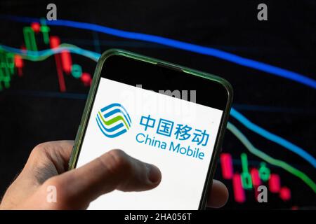 China. 4th Dec, 2021. In this photo illustration the Chinese state-owned telecommunication corporation China Mobile logo seen displayed on a smartphone with an economic stock exchange index graph in the background. (Credit Image: © Budrul Chukrut/SOPA Images via ZUMA Press Wire) Stock Photo