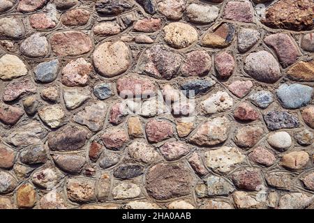 Ancient building wall from stones.  The background of old stones. Stonewall. Stock Photo