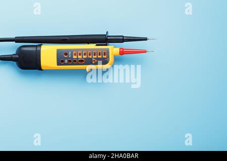 Two-pole voltage indicator close-up on a blue background. Testing and verification of electrical networks Stock Photo