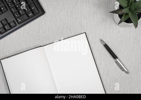 Book opened on a workspace. White pages for inscriptions. Stock Photo