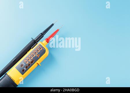 Yellow voltage indicator on a blue background. Free space Testing and verification of electrical networks Stock Photo