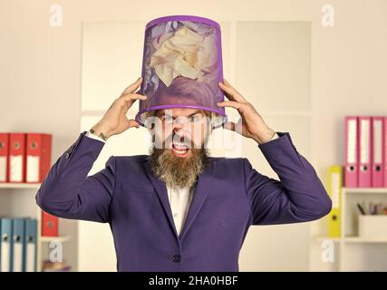 very hard working. crumpled paper in wastepaper basket. man read piece of paper. office worker digging in garbage bin. businessman hold trashcan. man Stock Photo