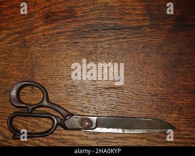 Old tailors scissors on wooden background Stock Photo