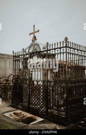 Gated, wrought iron tomb on a cloudy day in New Orleans Stock Photo