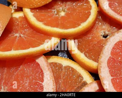 Sliced orange and grapefruit on a kitchen board Stock Photo