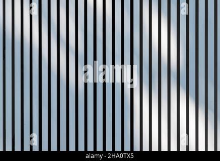Soft shadows pattern is over white metal fence. Background photo texture Stock Photo