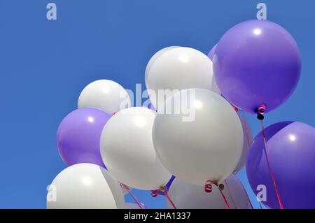 white and blue balloons in the city festival against clear sky Stock Photo