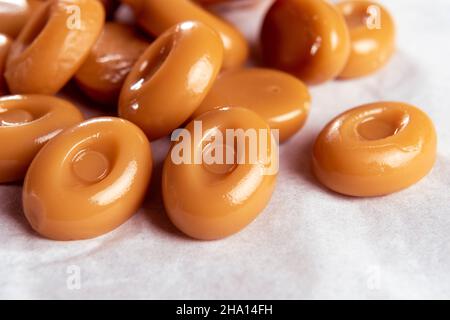 Sugar candies on a white napkin. Chocolate hard suckers close-up. Macro. Selective focus. Delicious creamy caramel Stock Photo