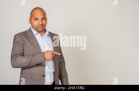 African man male discontent, expresses disgust and dislike points index finger to the side on copy space, disappointed with bad product with disgust Stock Photo