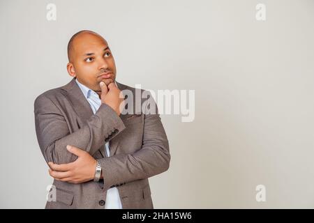 Serious pensive African man male, touching his chin, looking to the side, thinking about a solution in search of creative ideas concept. Solves Stock Photo