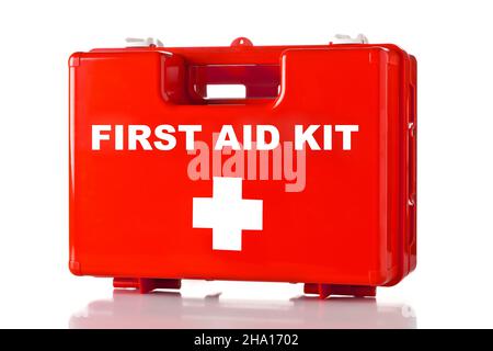 Red first aid medical kit box standing over white background Stock Photo