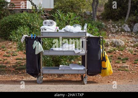 White towels and cleaning products stacked in room service trolley at hotel resort Stock Photo